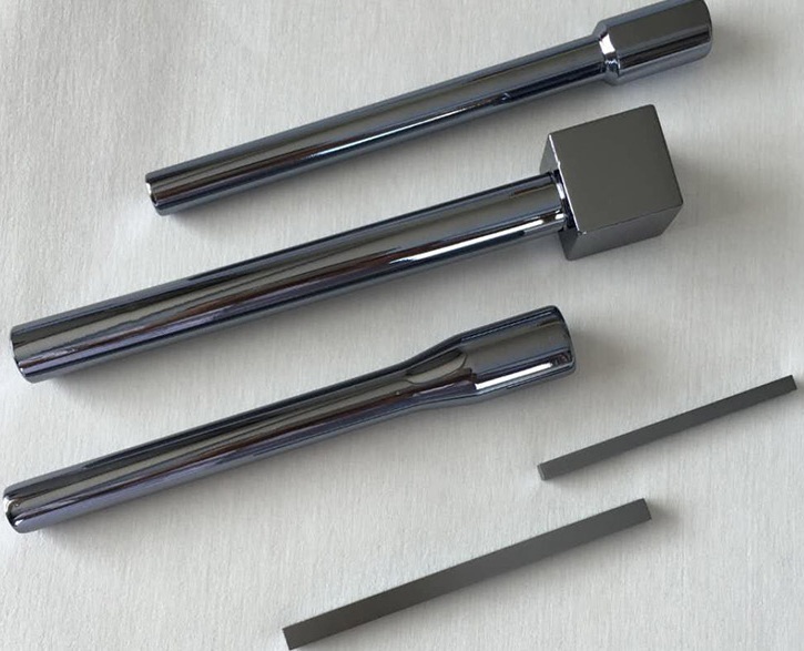 High-purity monocrystalline silicon seed crystals for the Czochralski (CZ) process, showing polished cylindrical rods and thin rectangular bars with a mirror-like metallic finish, placed on a textured cloth background